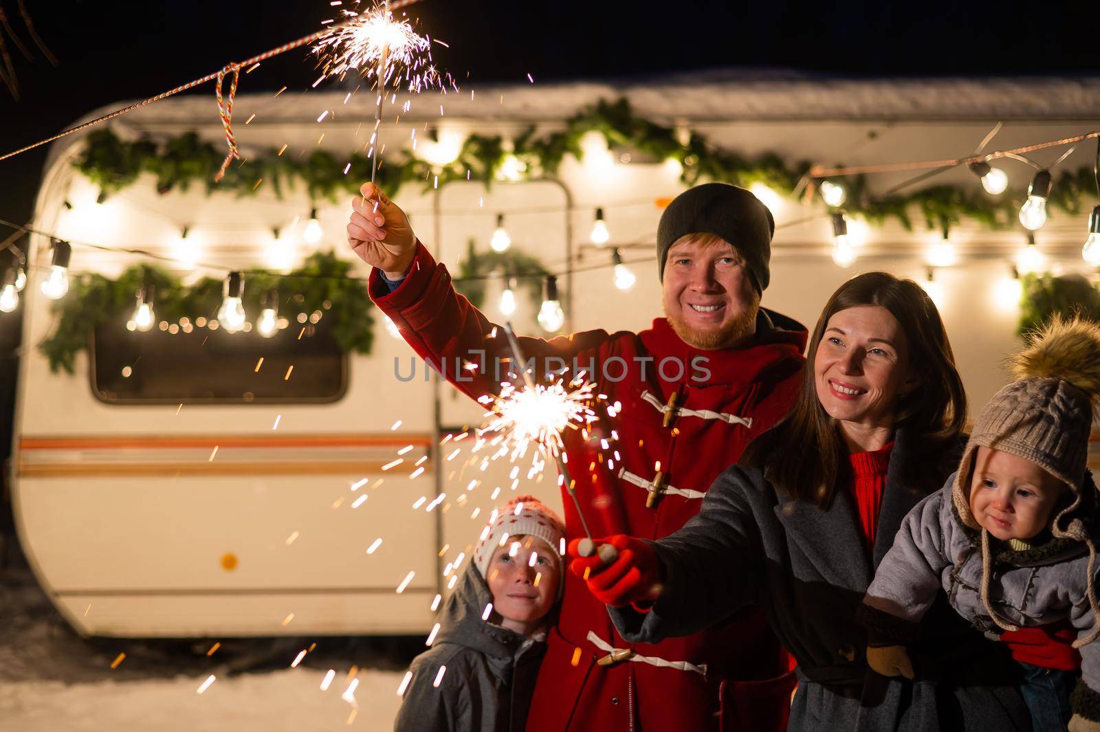 Happy parents with two sons celebrating christmas in motorhome