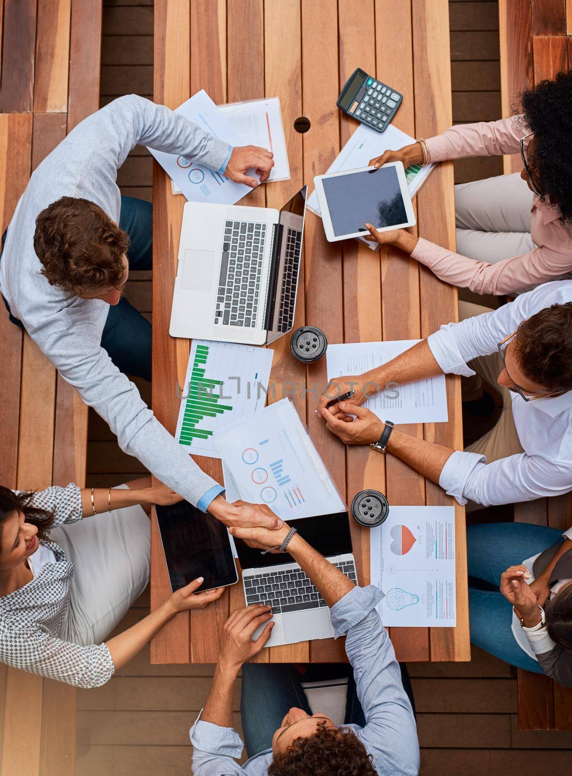 Finalizing the big business deal of the day. High angle shot of businesspeople shaking hands during a meeting outdoors