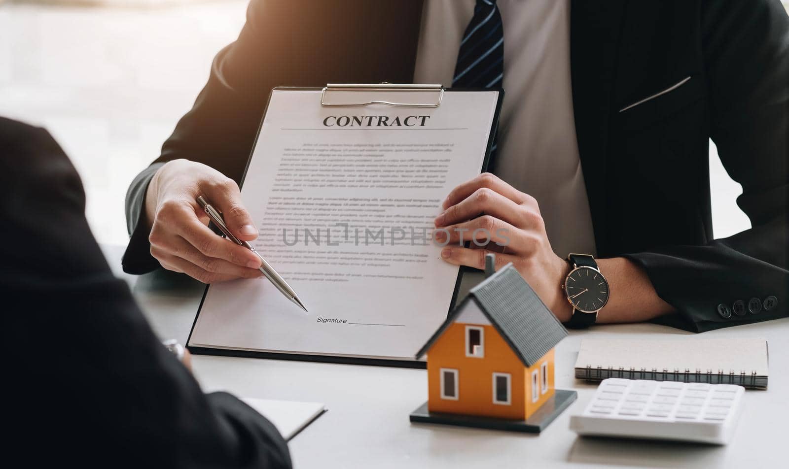 Real estate broker agent presenting and consult to customer to decision making sign insurance form agreement, buy and sell home model, concerning mortgage loan offer for and house insurance by wichayada