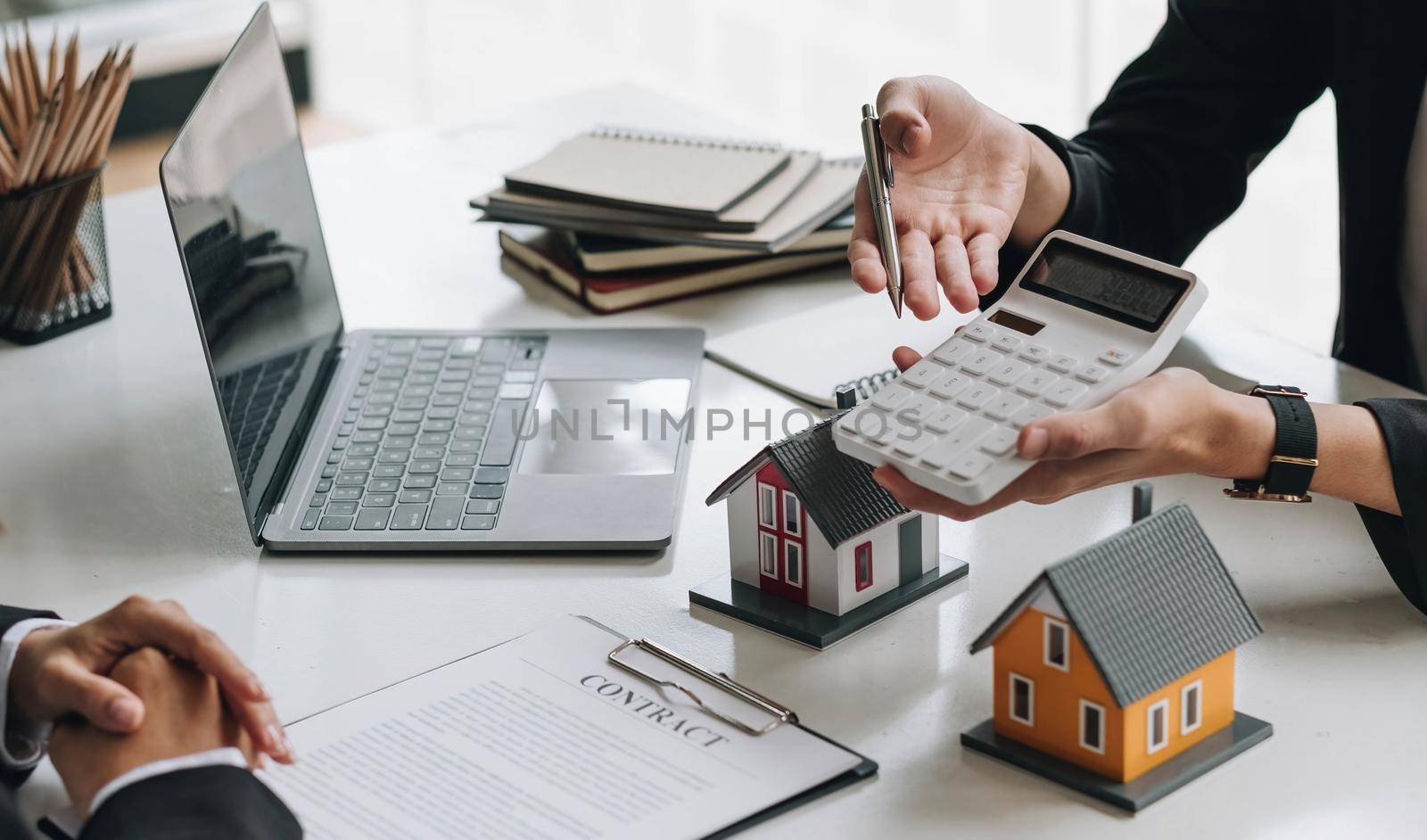 Real estate broker agent consult to customer to decision making sign insurance form and sending house model to client after approve, home model mortgage loan offer for and house insurance.