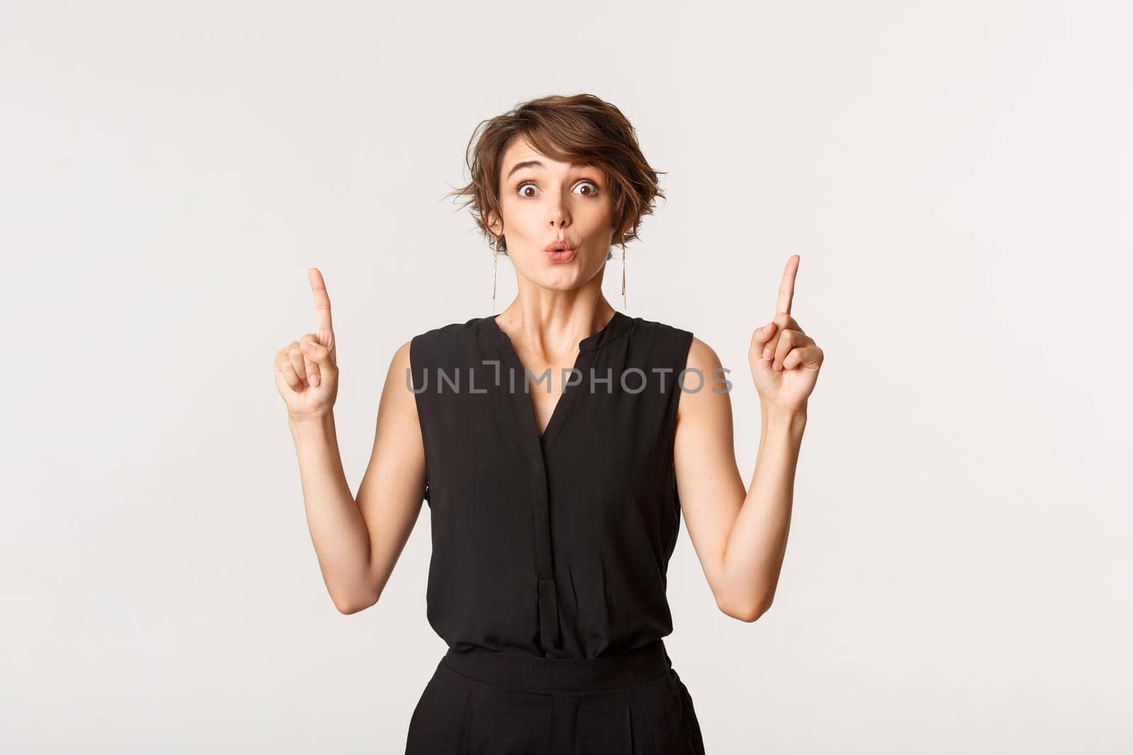 Image of surprised attractive woman looking impressed, pointing fingers up by Benzoix