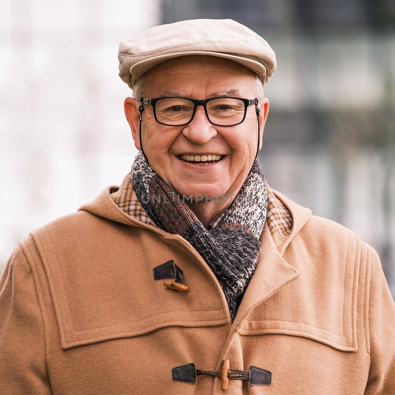 Outdoor portrait of cheerful senior man in winter coat.