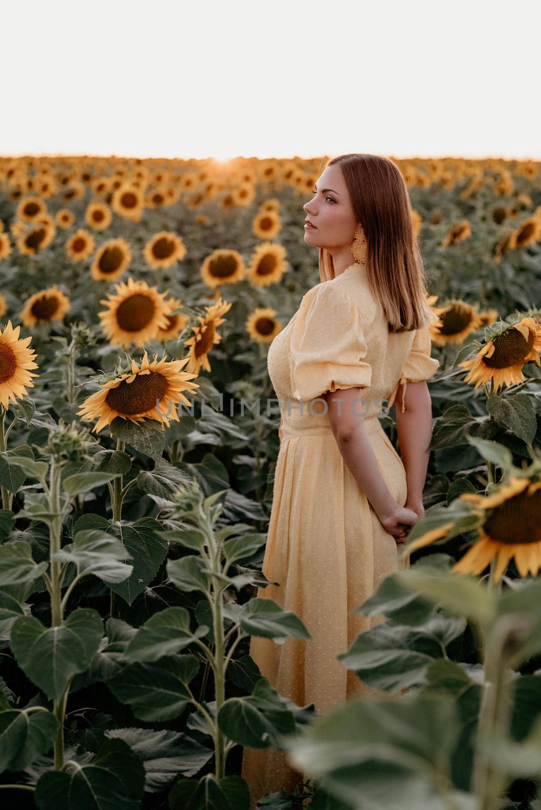 Pretty woman in retro dress posing in sunflowers field. Vintage timeless fashion, amazing adventure, countryside, rural scene, natural lifestyle. High quality photo