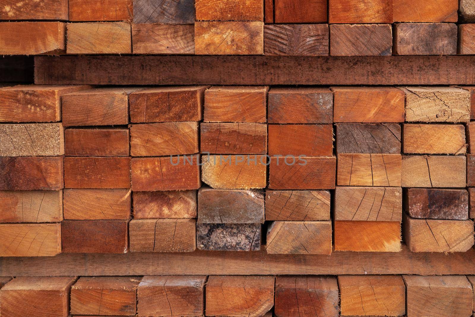 Stack of lumber in sawmill. Wood materail for construction industry. Pile of timber storage in warehouse. Lumber industrial. Closeup wooden boards in sawmill warehouse. Wood production industry. by Fahroni