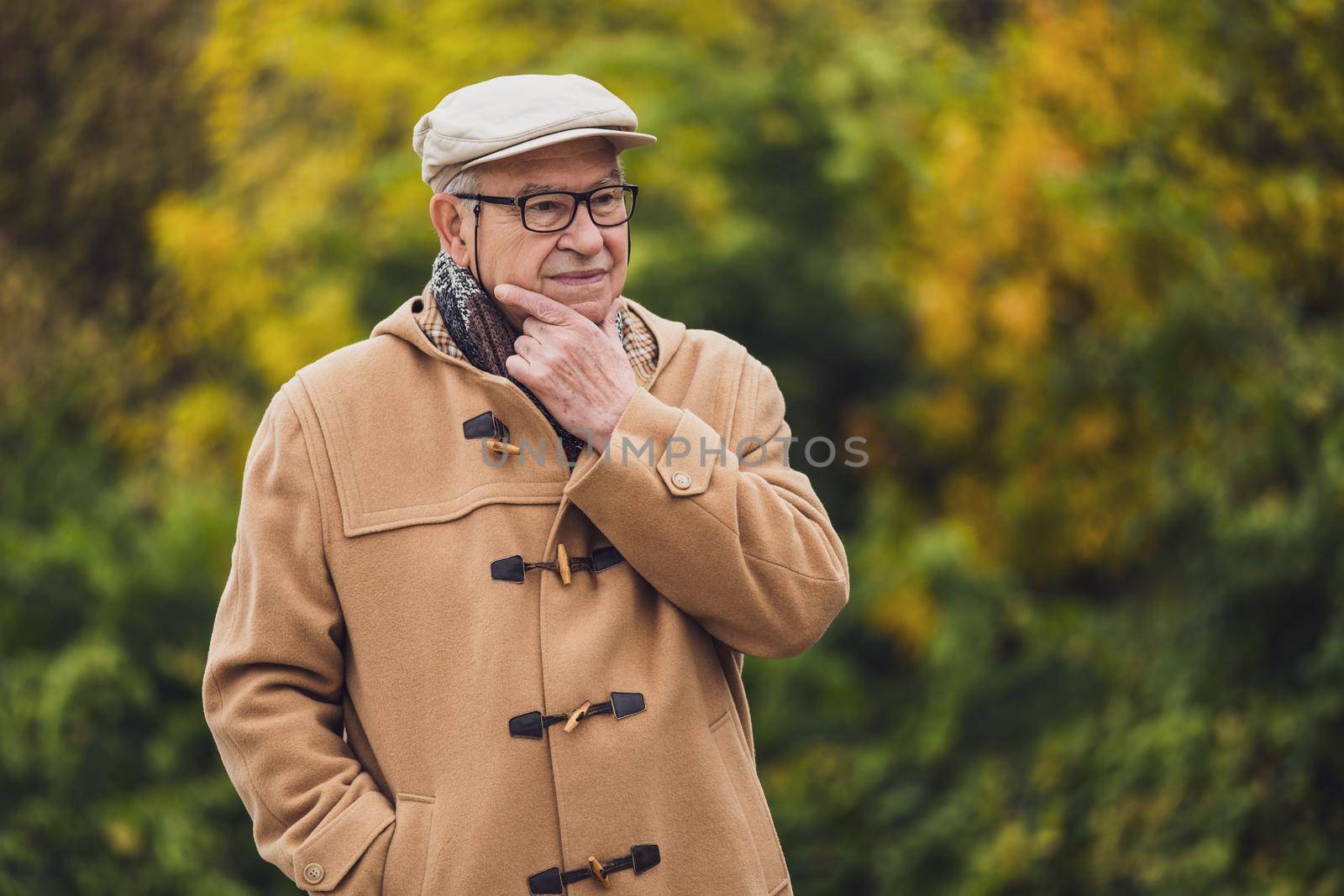 Outdoor portrait of worried senior man in winter coat.
