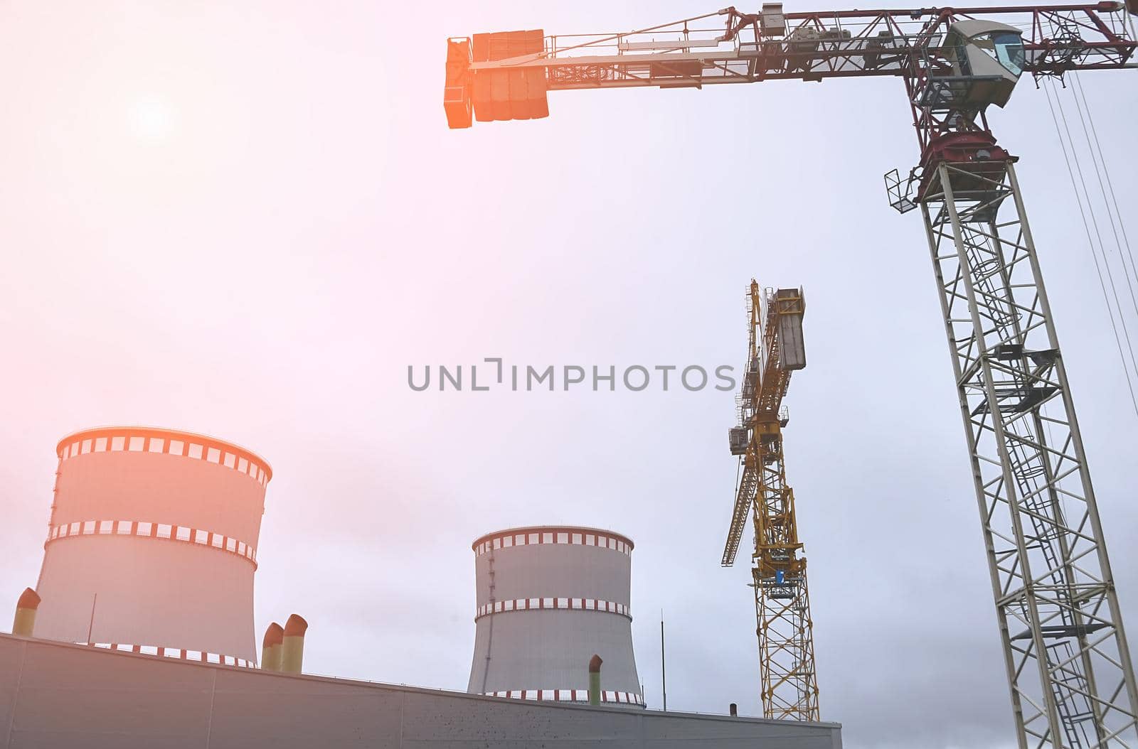 Cooling tower of an environmentally friendly nuclear power plant under construction and a lifting tower crane