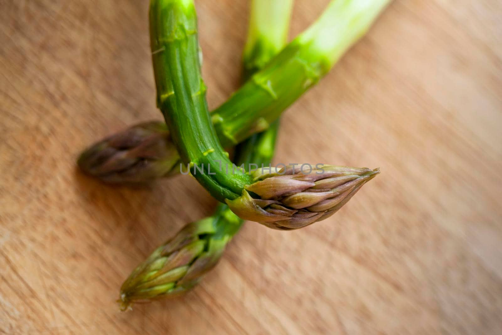 Close up of green asparagus on a wooden table in a kitchen