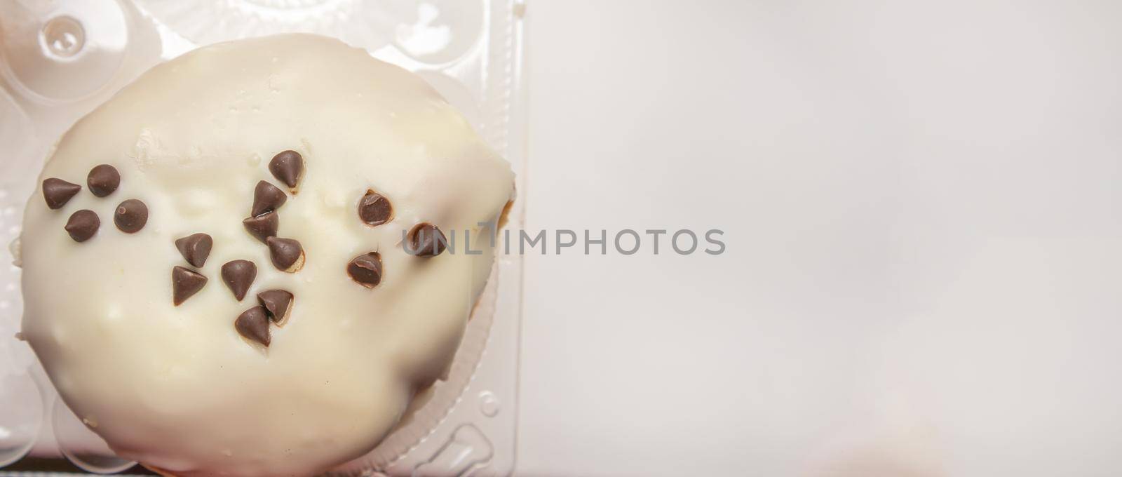 Delicious donut with icing sugar and chocolate chips top view, banner with a copy of the space on the right.