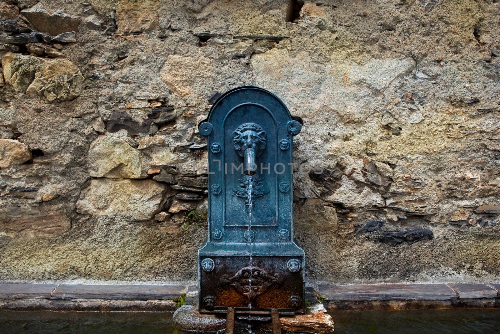 Old cast iron fountain at the wash house of a village in the Pyrenees, France