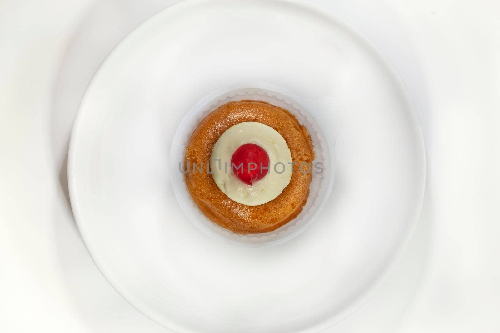 French rum cake and cherry on a plate