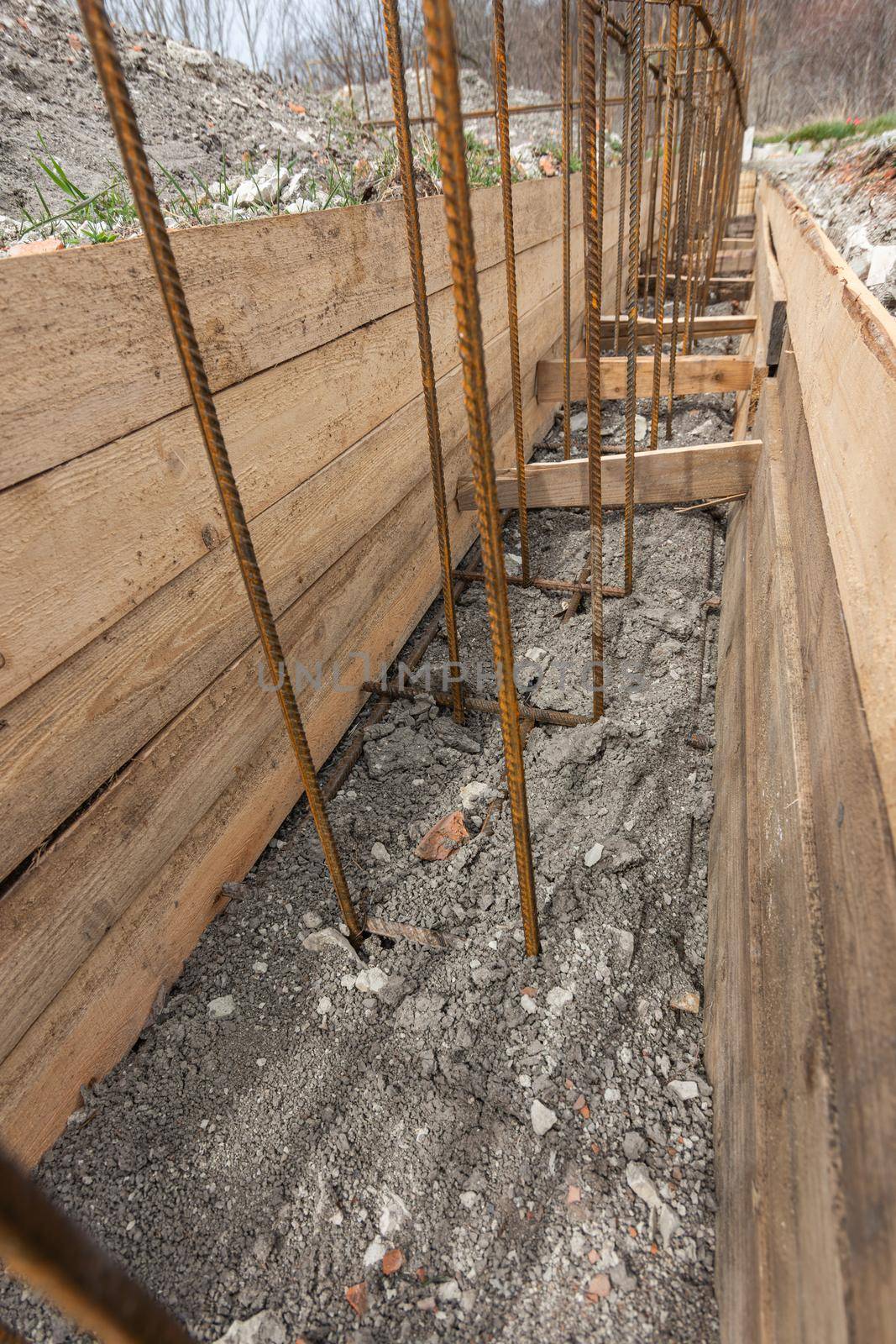 Reinforcement of a shallowly buried strip foundation of a low-rise residential building, the trench is covered with earth