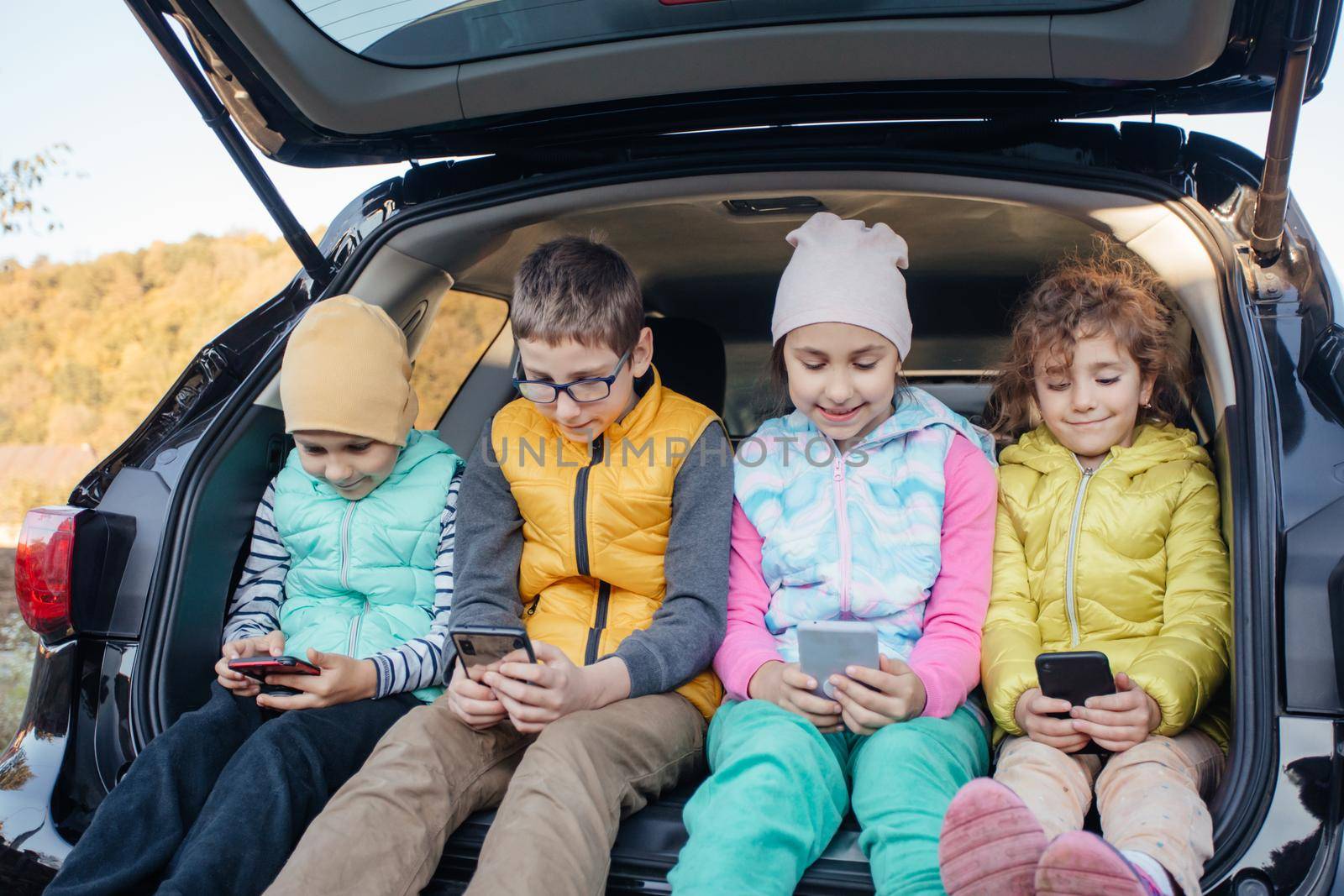 Children sitting on the car truck with smartphones by oksix
