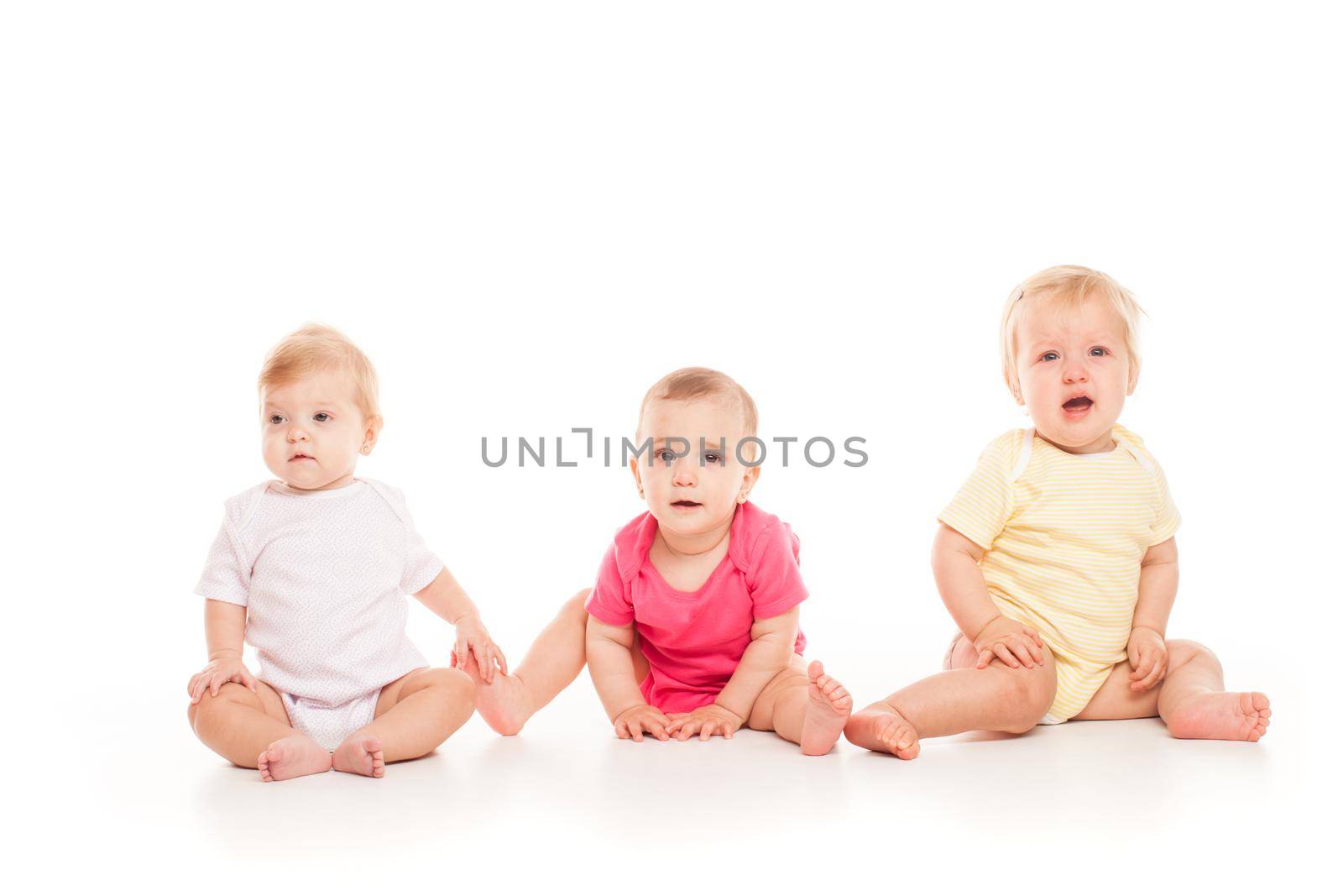 Three babies sitting isolated on a white by oksix