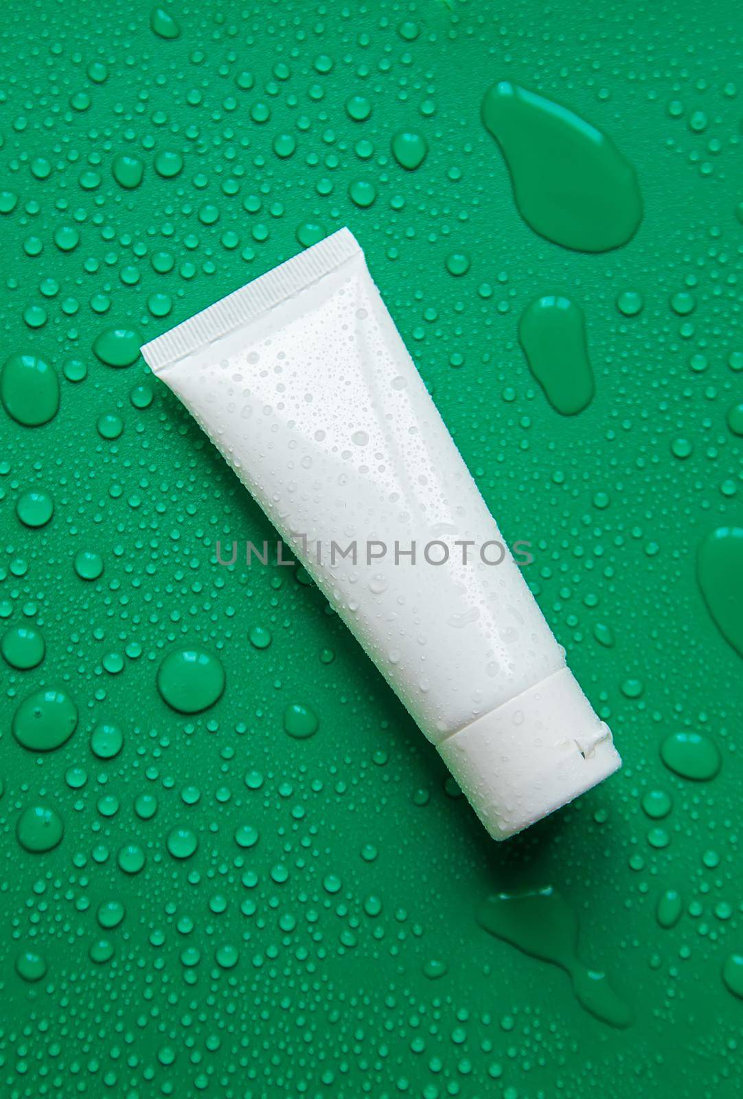 Cosmetics with moisturizing on a wet background. Selective focus. by yanadjana