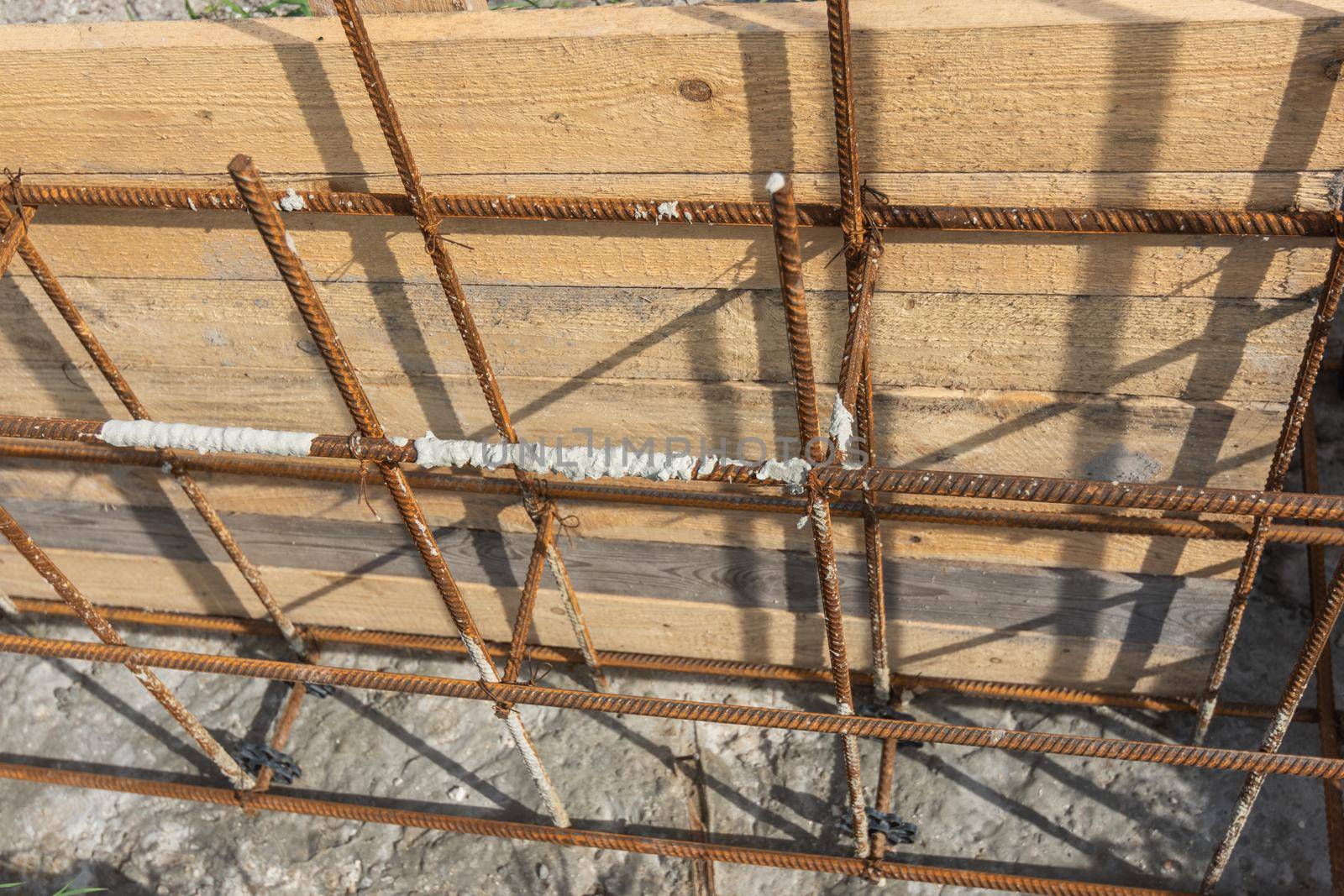 Tied reinforcement and mounted strip foundation formwork close-up by Madhourse