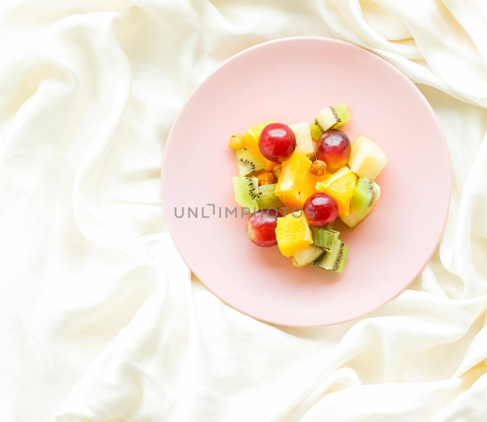 juicy fruit salad on silk, flatlay - healthy lifestyle and breakfast in bed concept by Anneleven