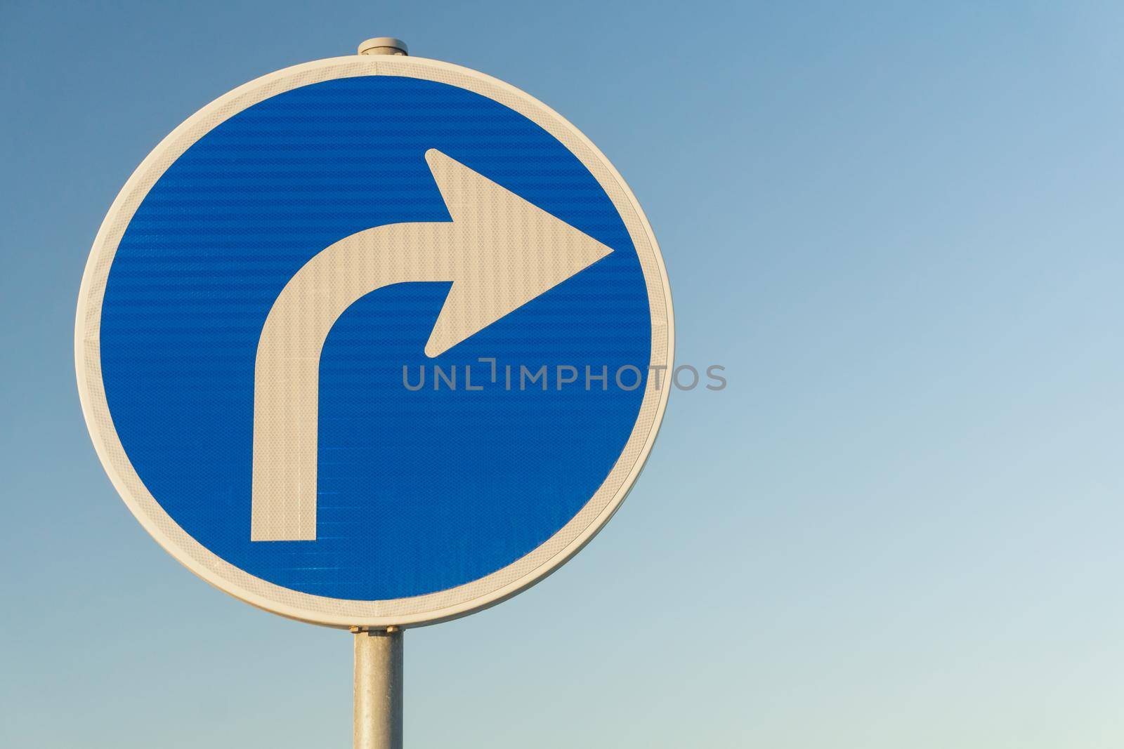 Road sign blue right turn signal on sky background close up