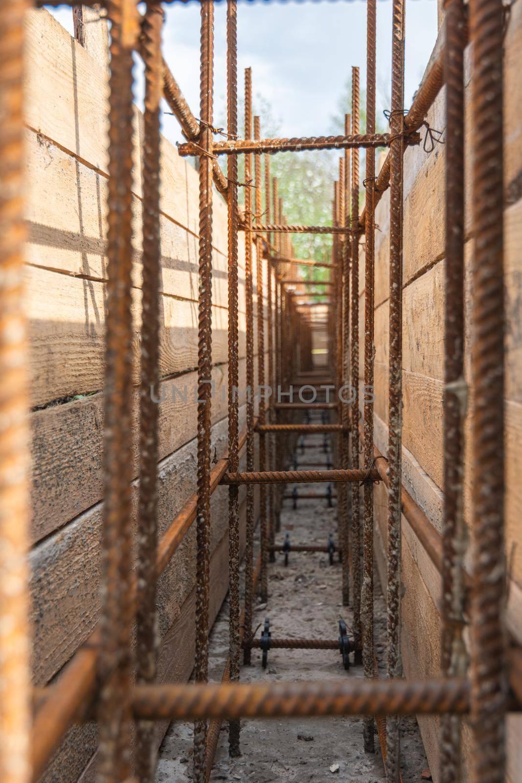 Close-up of tied reinforcement and mounted strip foundation formwork, view inside the trench a