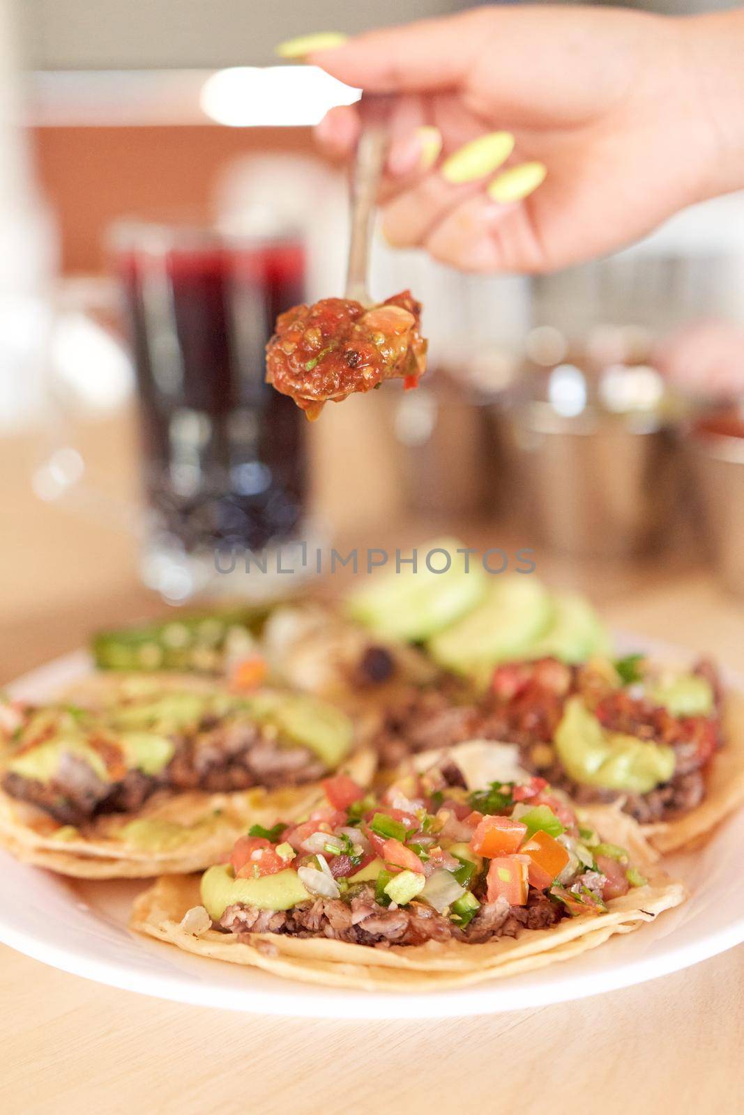 Girl adding salsa to her delicious tacos by JpRamos