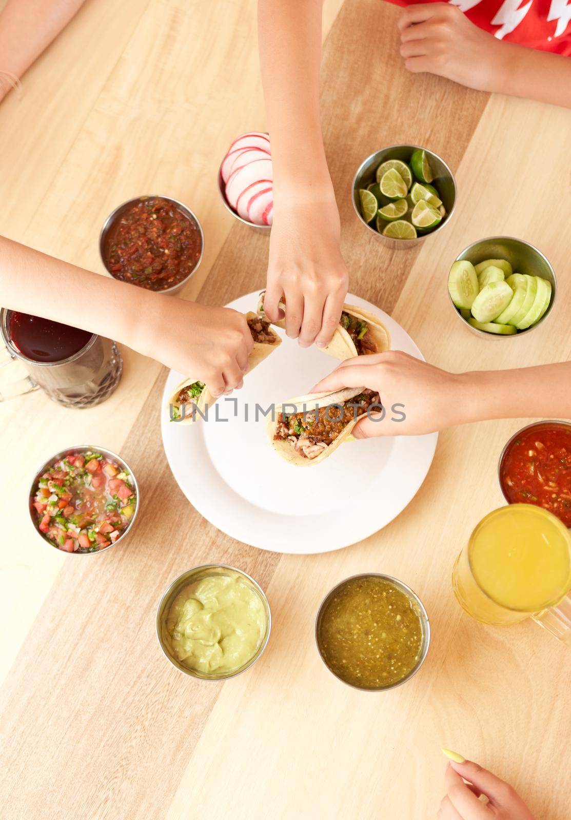 group of people eating delicious tacos al pastor with salsa and a variety of ingredients. Mexican taco with salsa, taco al pastor