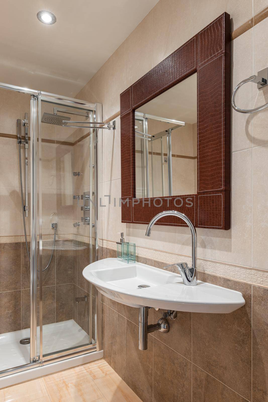 Interior of a new luxury bathroom with a mirror in a leather frame