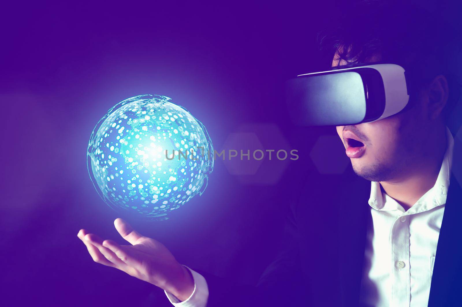 Businessman wearing Virtual reality headset with globe hologram on his hand. Business technology and Metaverse concept