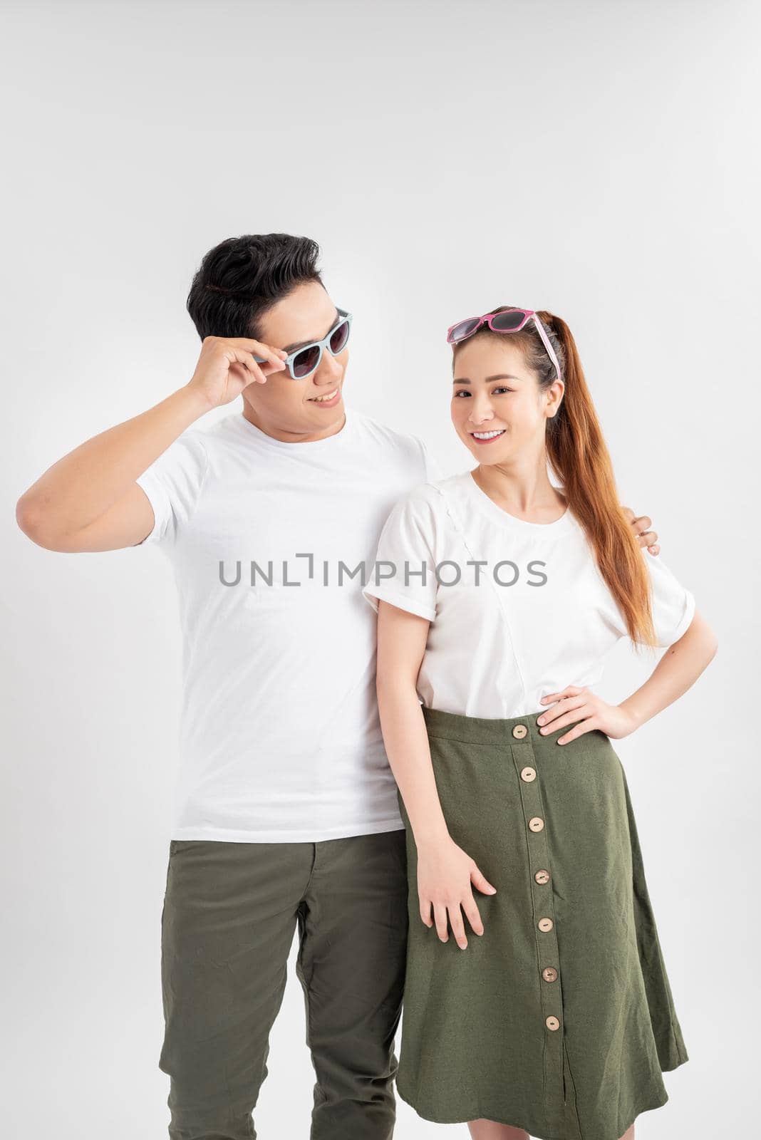 Studio shot of two surprised terrific woman and man look in bewilderment, touch rim of spectacles, being amazed by sudden news, stand against white background