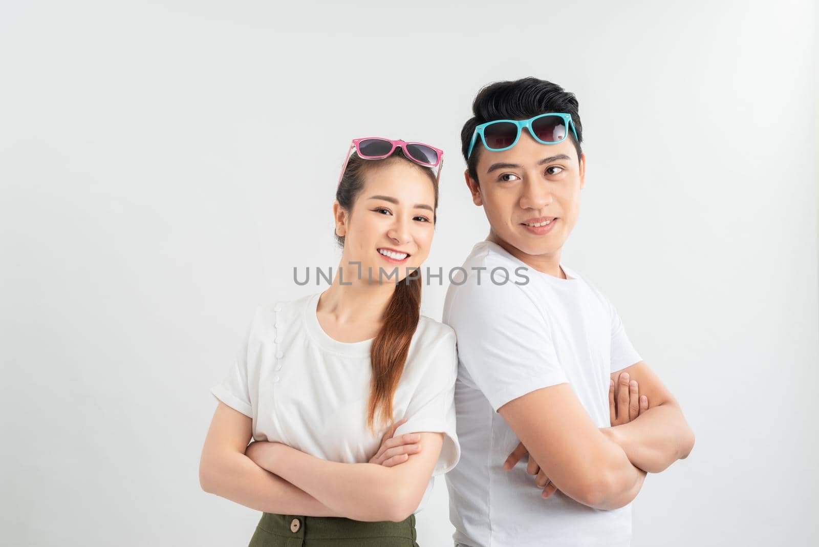 emotions and people concept - portrait of happy couple in white t-shirts celebrating success over white background by makidotvn