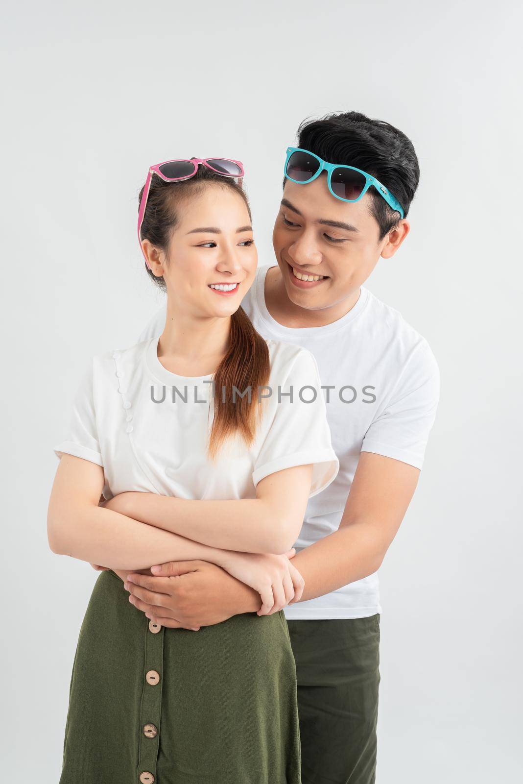 Young couple embracing and posing on white background by makidotvn