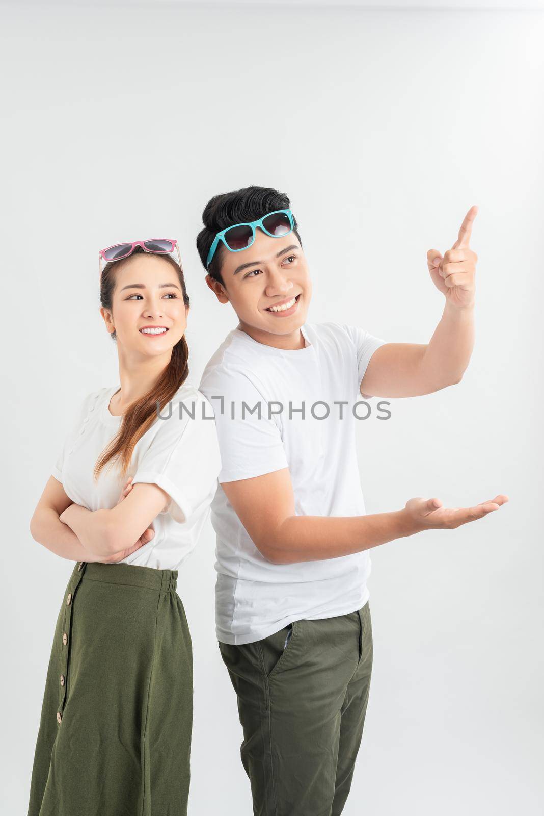Copyspace shot of couple presenting something over white background and looking at it shocked and amazed. by makidotvn