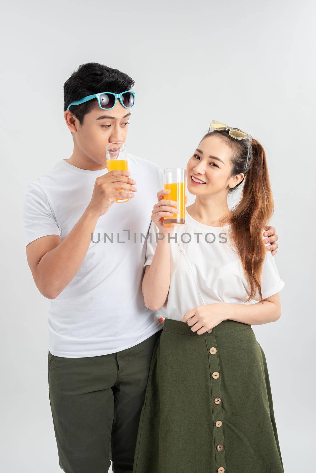 love, family, healthy food and happiness concept - smiling happy couple drinking juice on white background by makidotvn