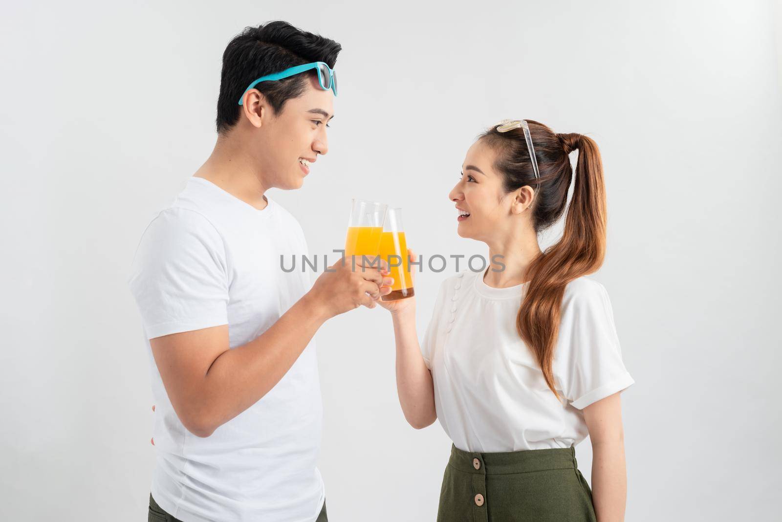 A healthy young asian couple drinking orange juice