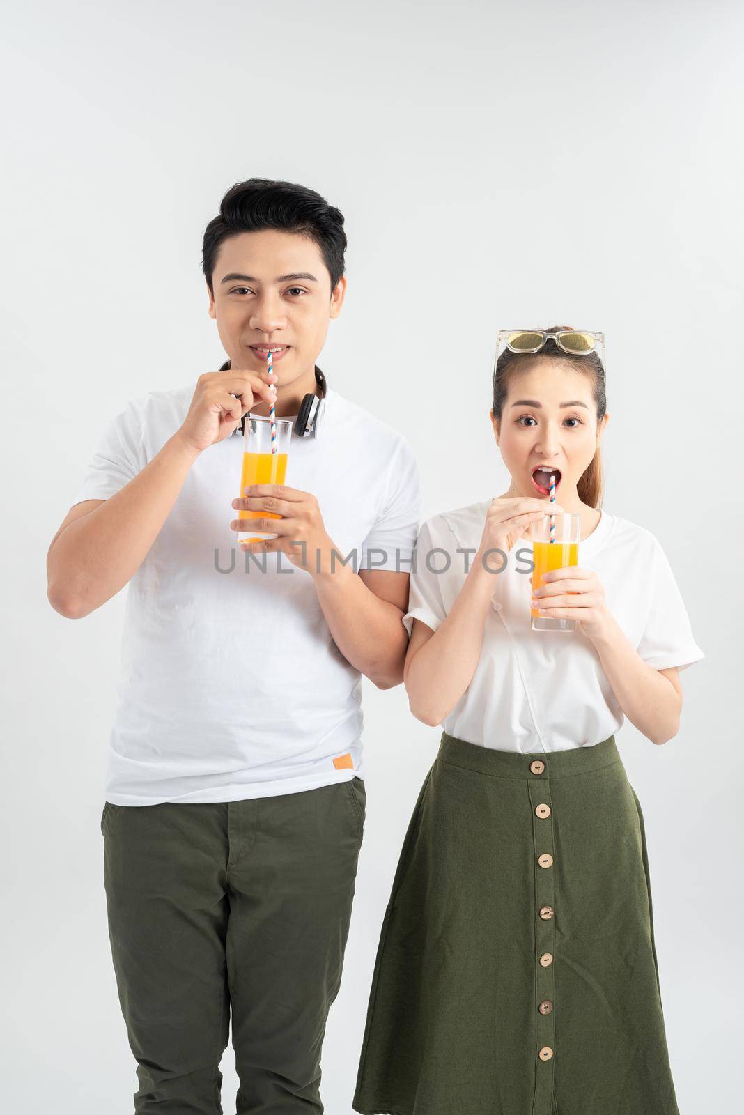 love, family, healthy food and happiness concept - smiling happy couple drinking juice on white background