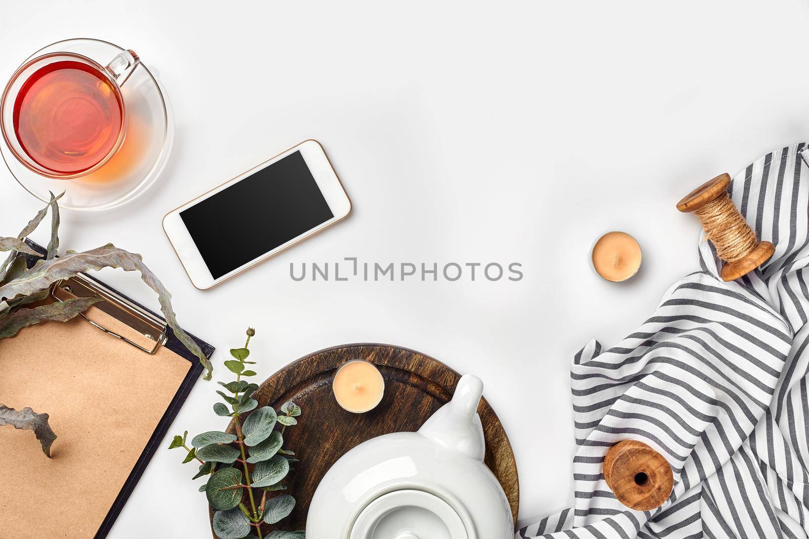 Still life with tea cup and the contents of a workspace composed. Different objects on white table. Flat lay. Top view. Copy space