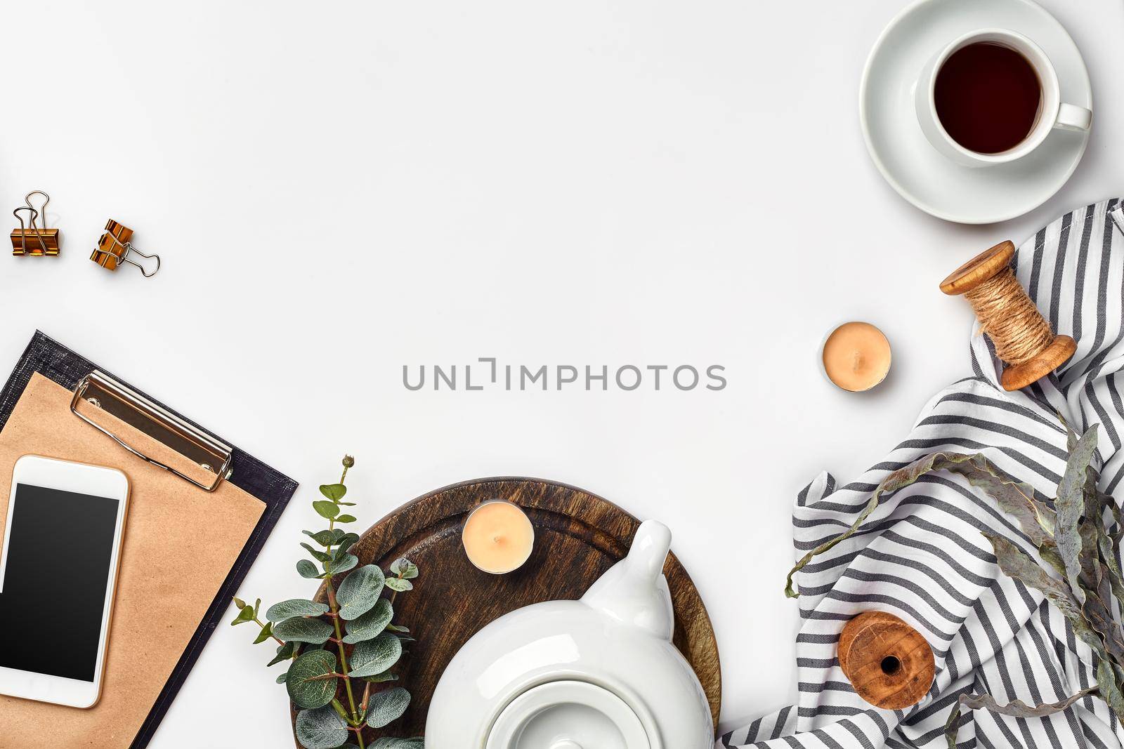 Still life with tea cup and the contents of a workspace composed. Different objects on white table. Flat lay. Top view. Copy space