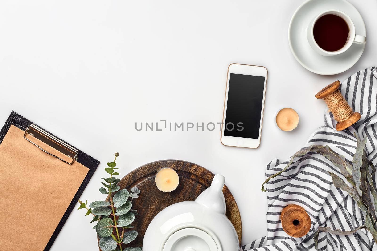 Still life with tea cup and the contents of a workspace composed. Different objects on white table. Flat lay. Top view. Copy space