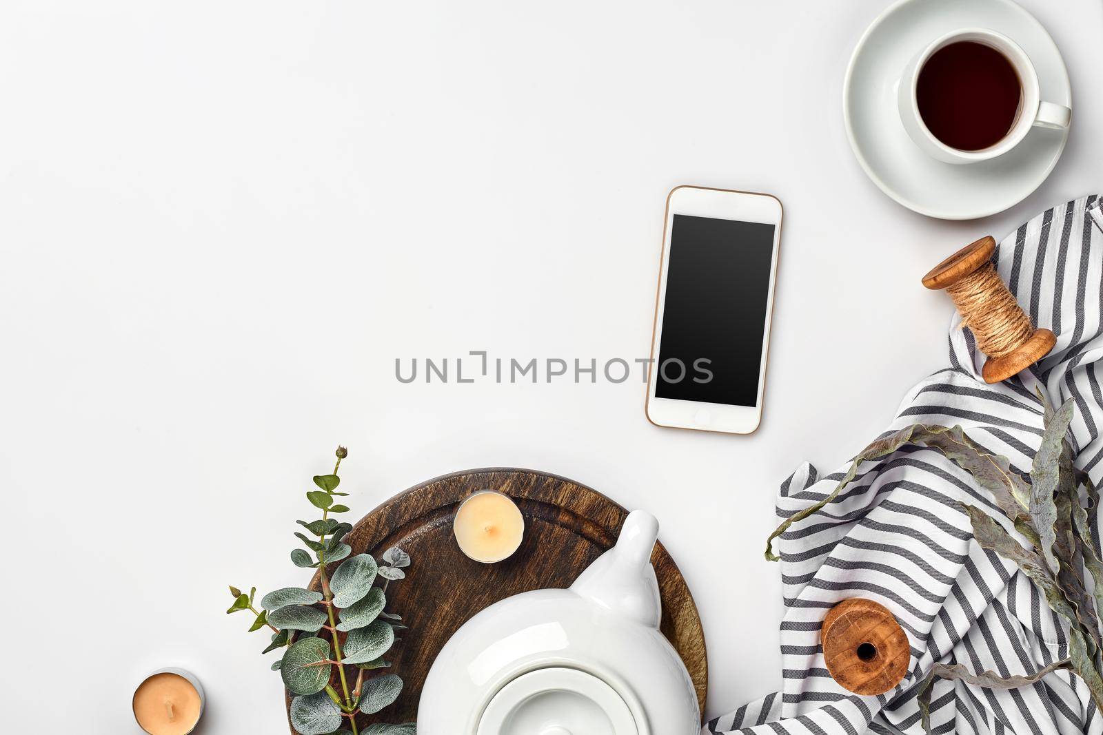 Still life with tea cup and the contents of a workspace composed. Different objects on white table. Flat lay. Top view. Copy space