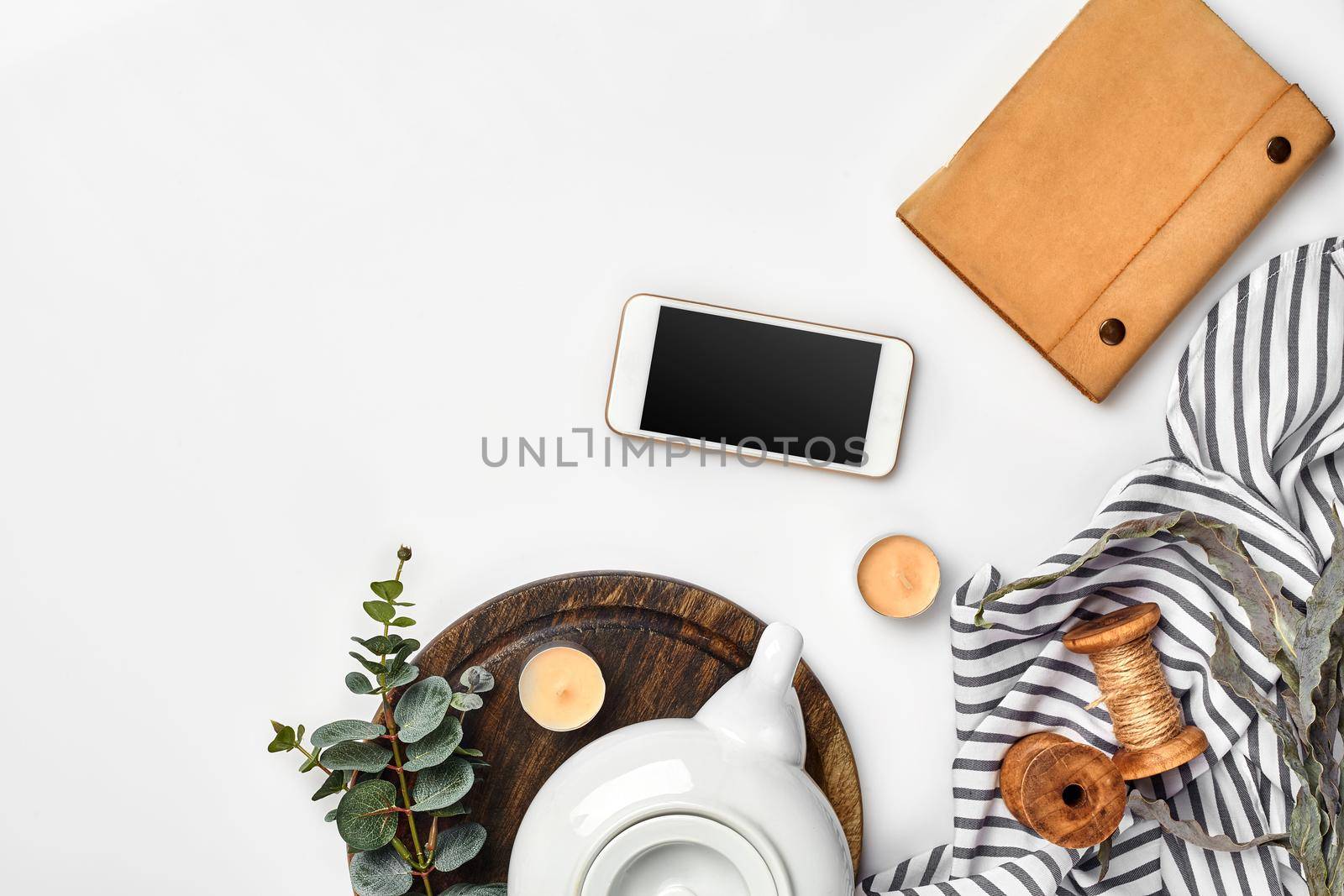 Still life with tea cup and the contents of a workspace composed. Different objects on white table. Flat lay. Top view. Copy space