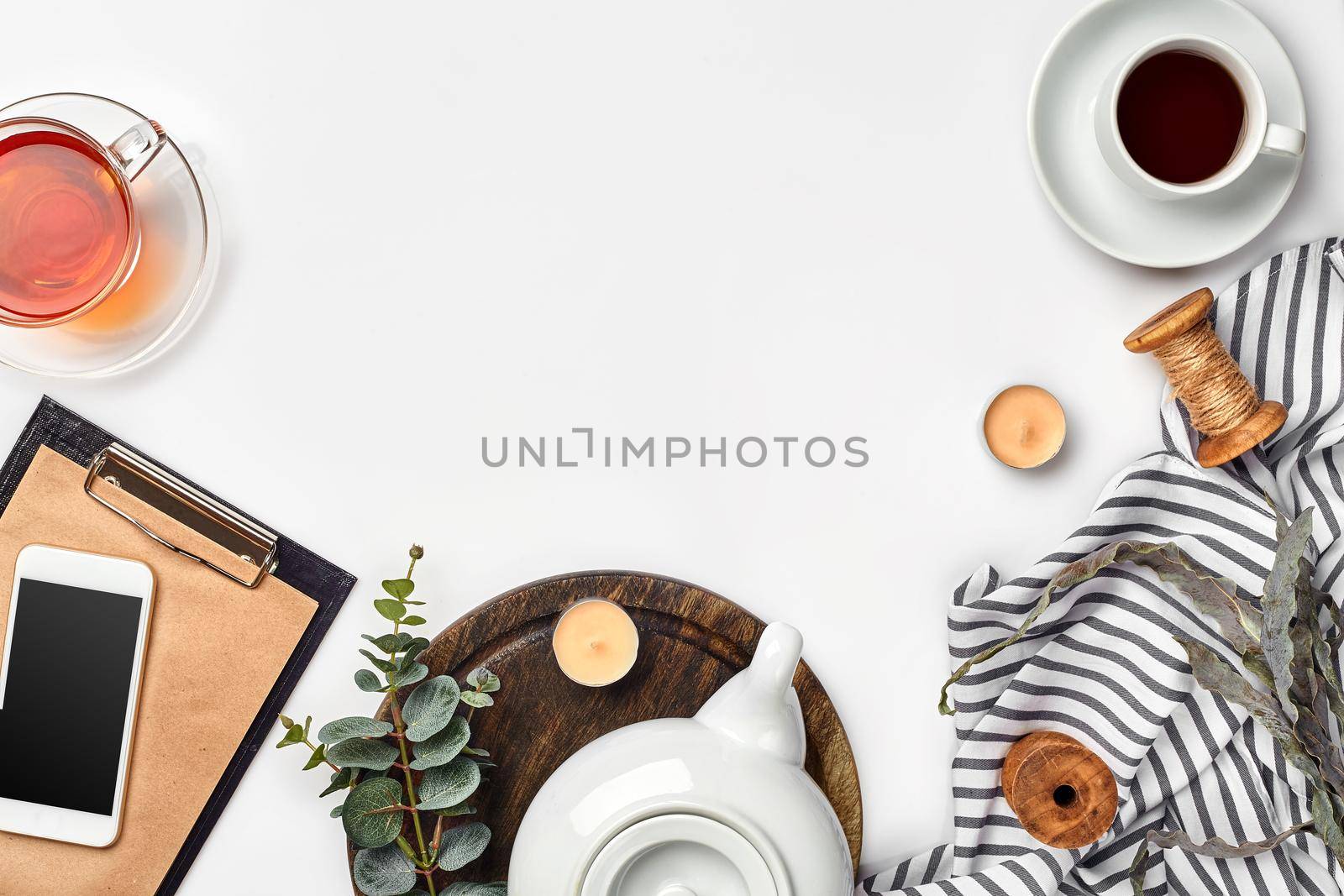 Still life with tea cup and the contents of a workspace composed. Different objects on white table. Flat lay. Top view. Copy space