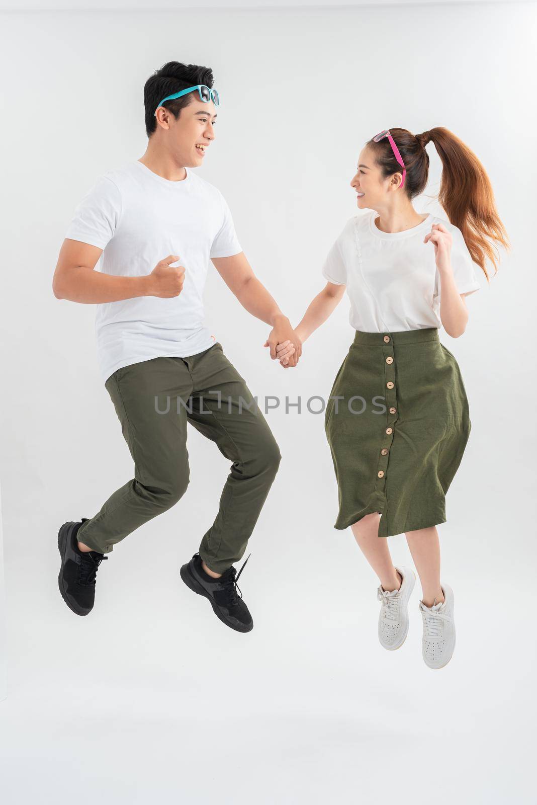 Full length shot of jumping couple having fun together. by makidotvn