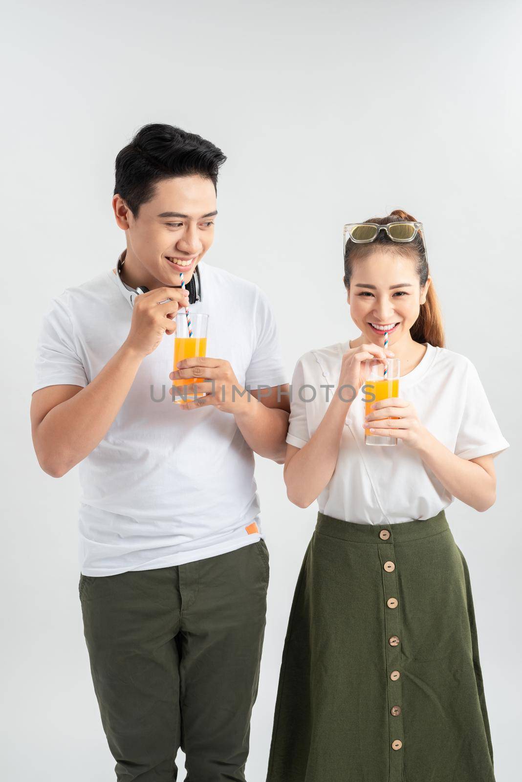 love, family, healthy food and happiness concept - smiling happy couple drinking juice on white background by makidotvn