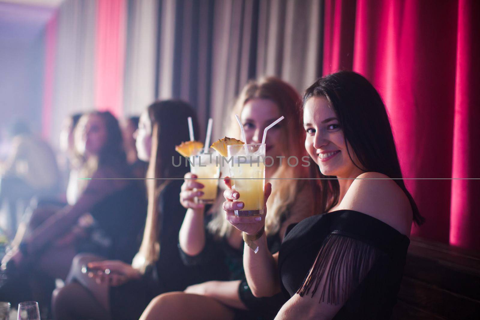 Group of dancing young people enjoying night in club by oksix