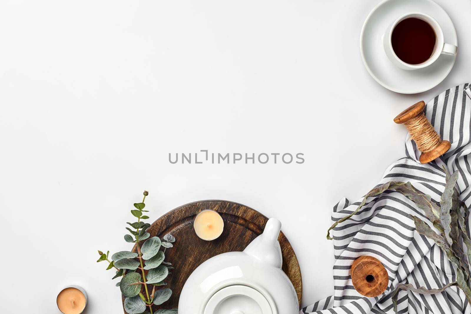 Still life with tea cup and the contents of a workspace composed. Different objects on white table. Flat lay by nazarovsergey