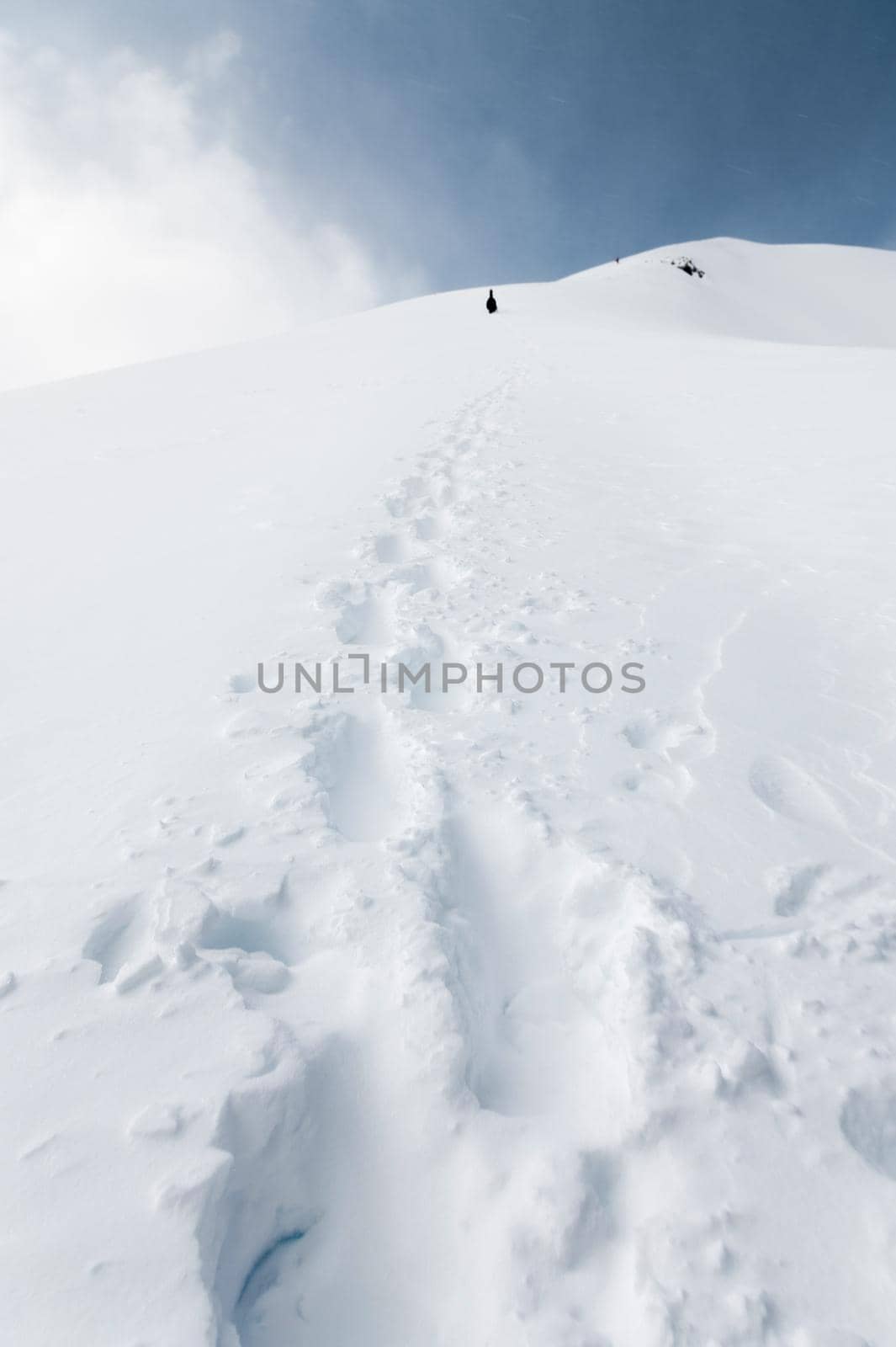 Single footprint from a man in deep snow, mountains, expedition concept.
