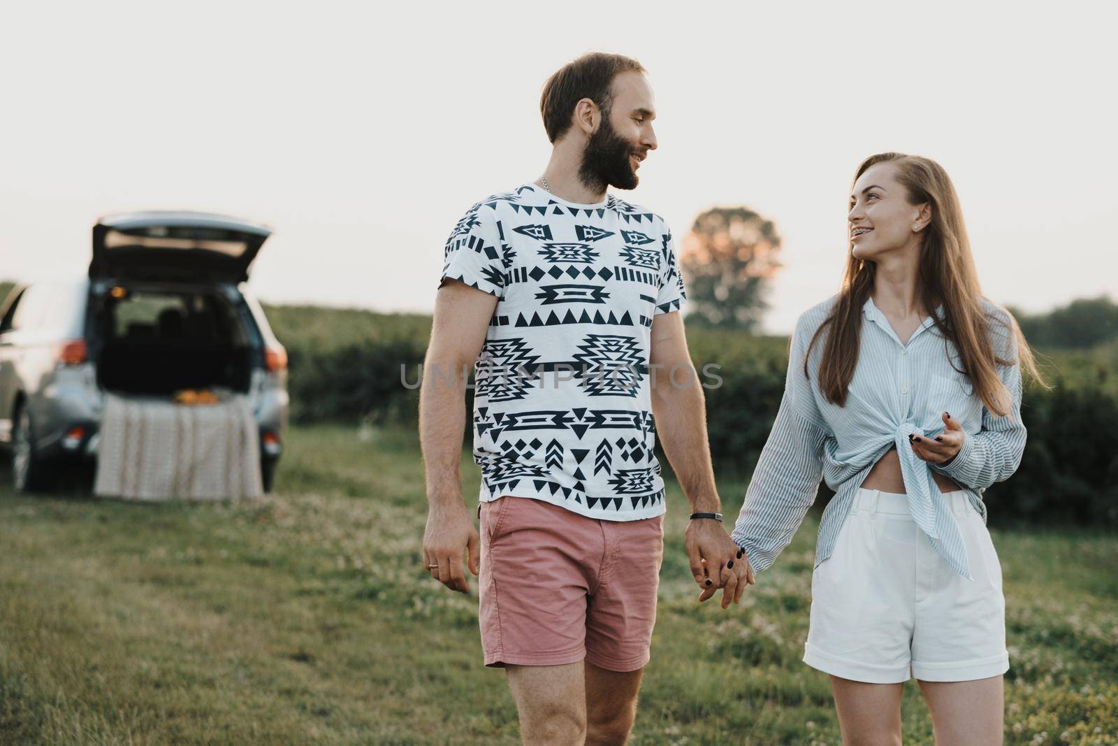 Middle-aged couple enjoying road trip, caucasian man and woman walking outdoors in nature outside the city