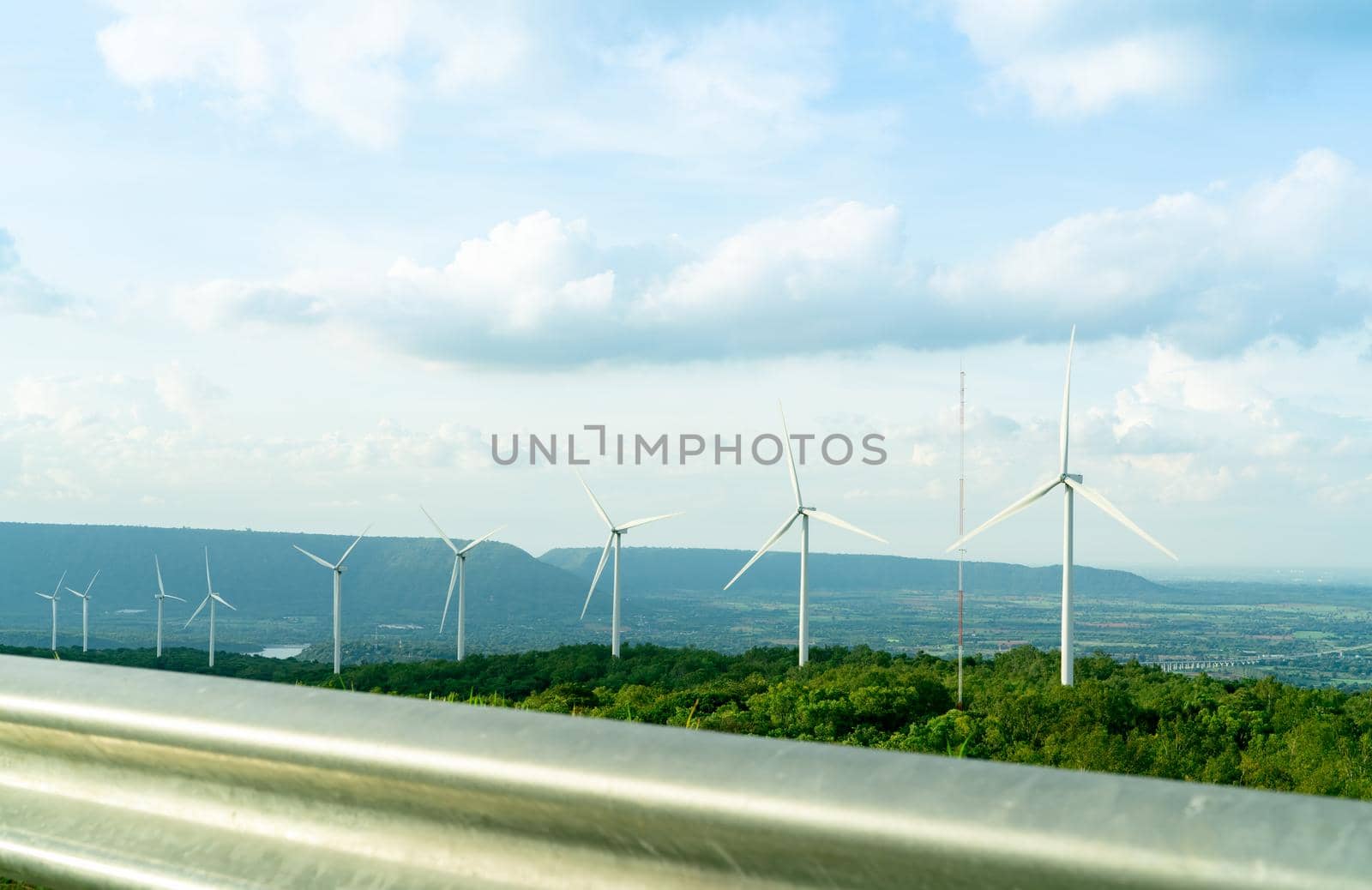 Wind energy. Wind power. Sustainable, renewable energy. Wind turbines generate electricity. Windmill farm on a mountain with blue sky. Green technology. Renewable resource. Sustainable development.