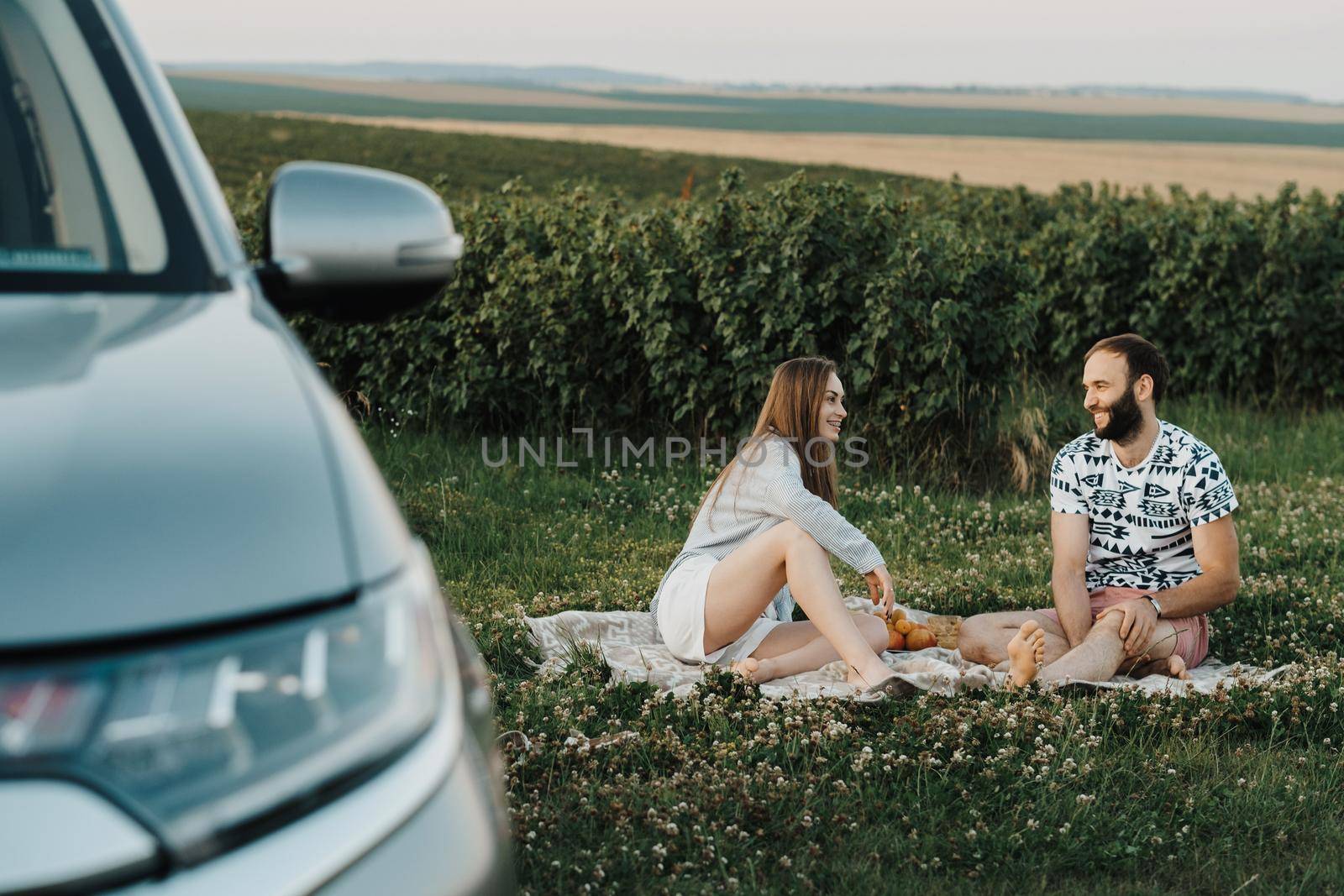 Happy middle-aged couple having picnic outside the city, cheerful man and caucasian woman enjoying weekend together on road trip