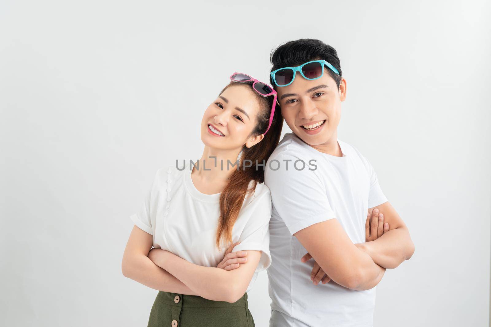 Cheerful hsppy man and woman with crossed hands standing back to back.