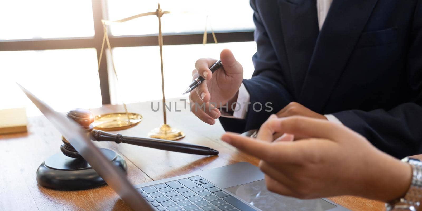 Business and lawyers discussing contract papers with brass scale on desk in office. Law, legal services, advice, justice and law concept picture with film grain effect.