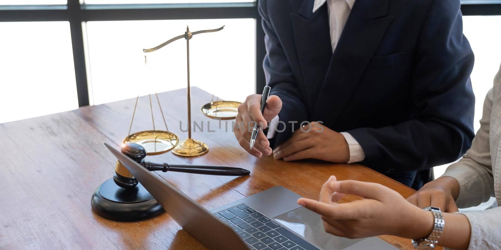 Business and lawyers discussing contract papers with brass scale on desk in office. Law, legal services, advice, justice and law concept picture with film grain effect.